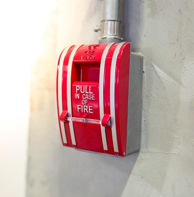 A traditional commercial fire alarm system with the words "Pull in case of fire.