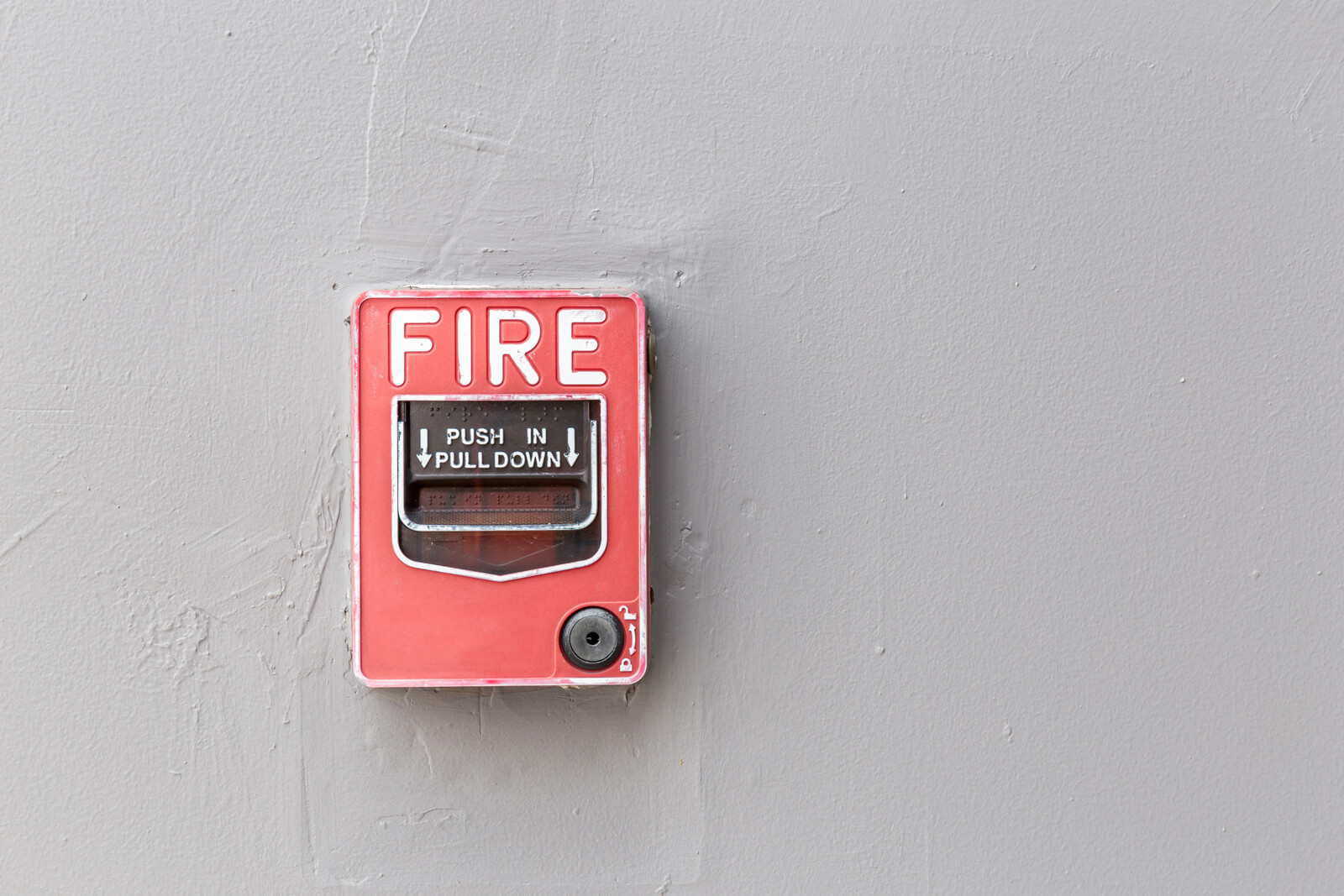 a commercial fire alarm switch on the exterior wall of a building