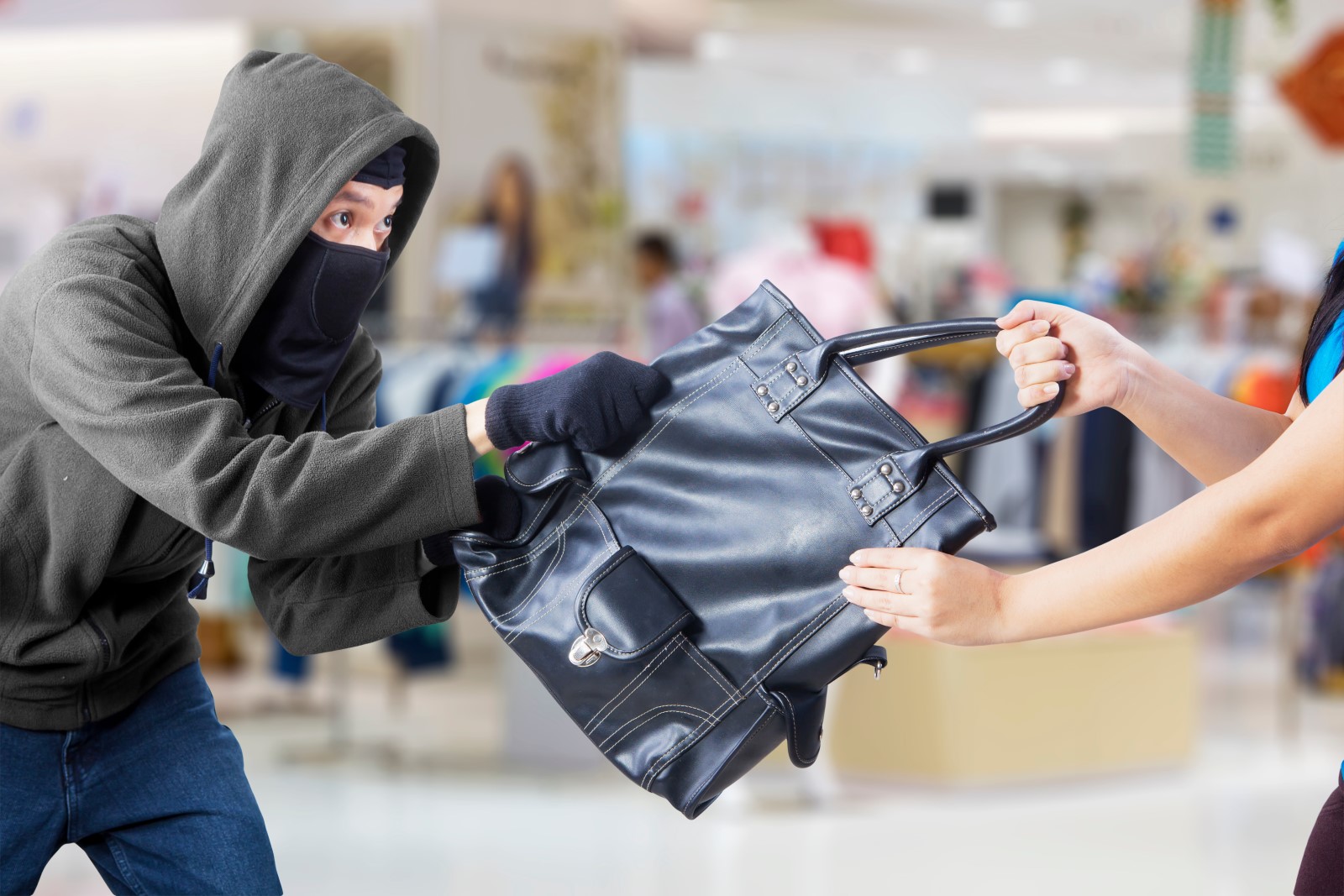 Young woman protects her handbag from theif.