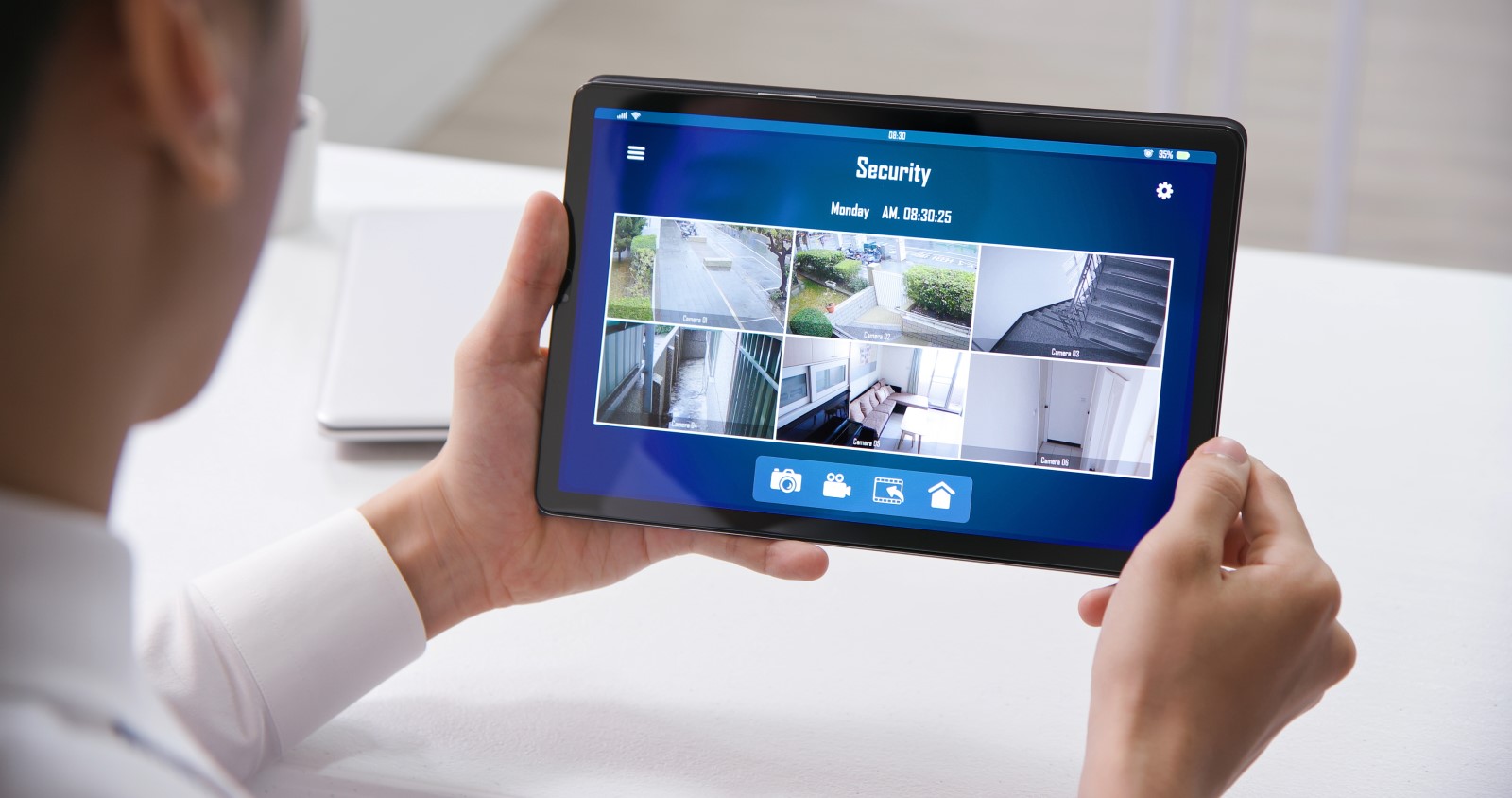 A business owner monitors his business surveillance video system on his tablet.