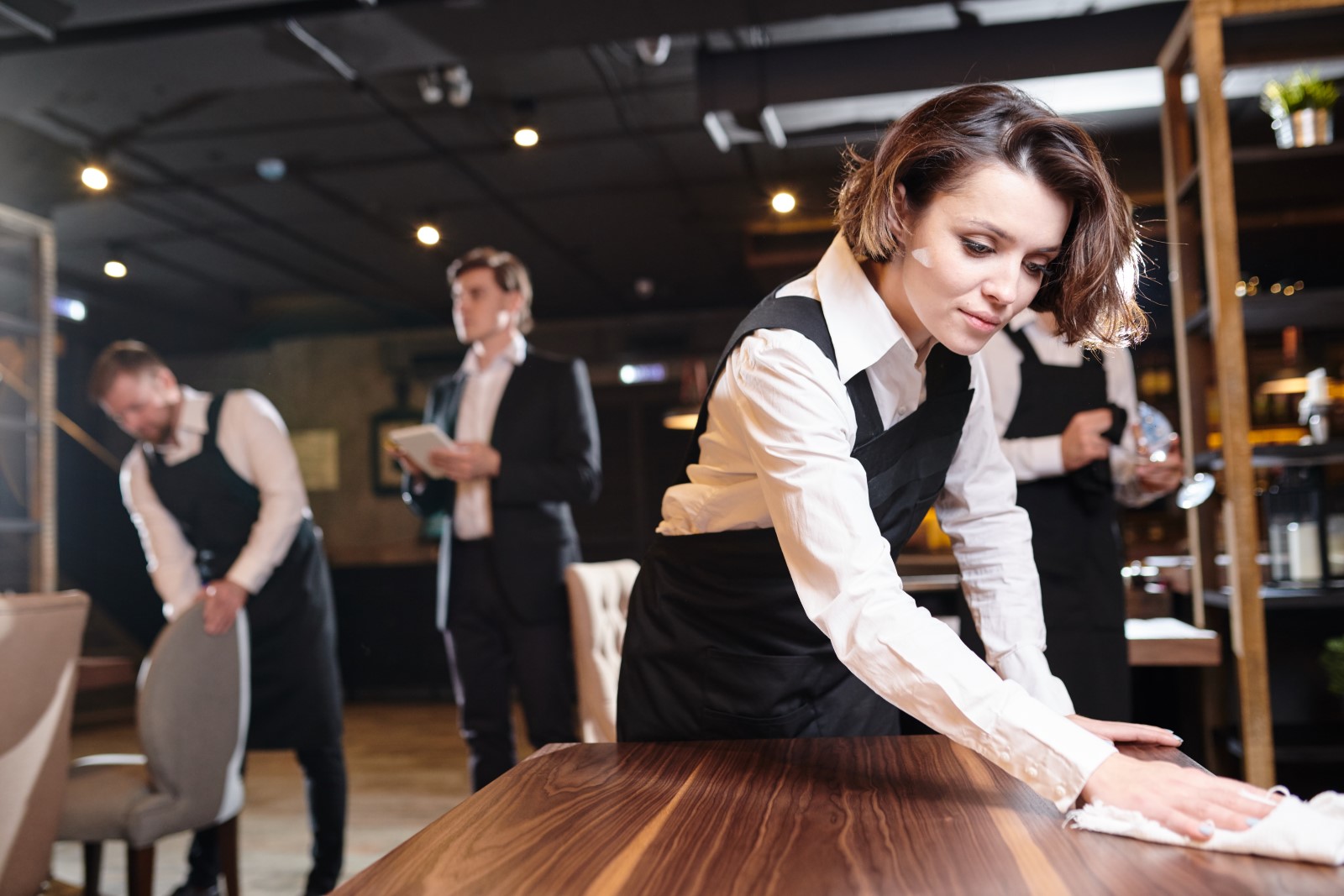 restaurant workers clean the dining room after a busy shift