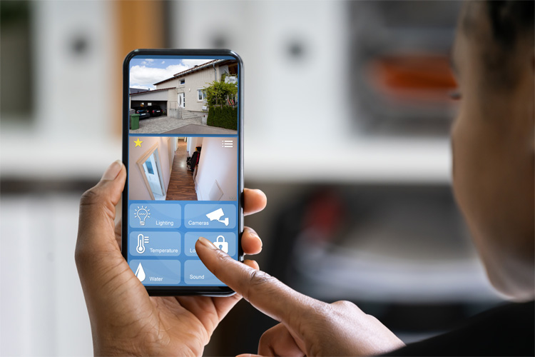 A homeowner controlling her security system with her smartphone.