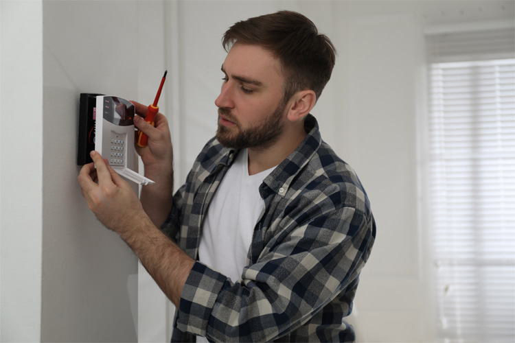 A homeowner installing a DIY alarm system from Security Alarm