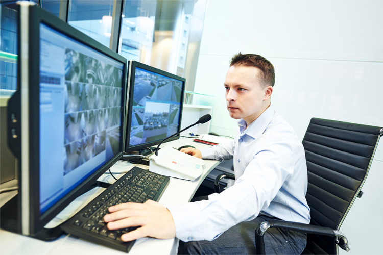 A man monitoring a residential security system.