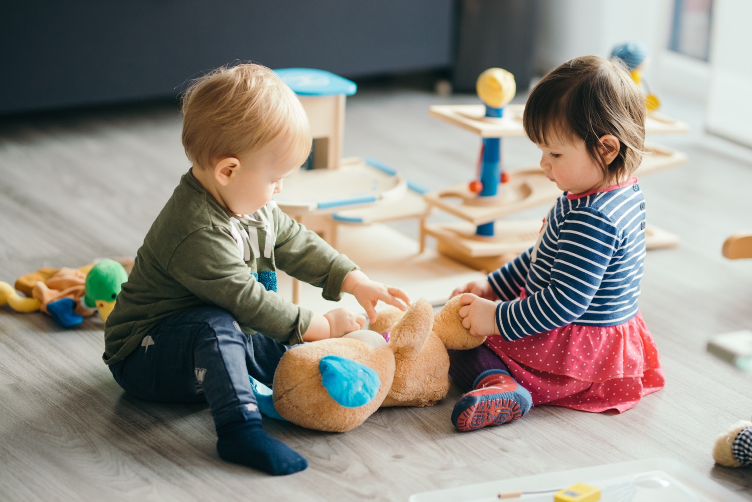 A little boy and girl playing in a home protected by a fire alarm system.