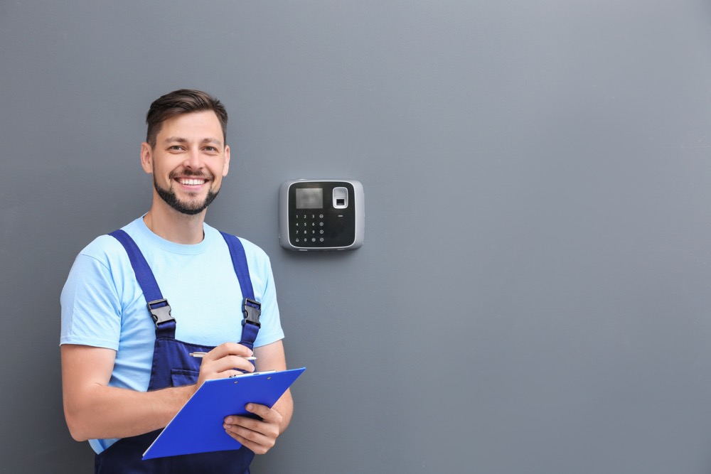 A friendly security technician taking over the security monitoring service of a customer's home.