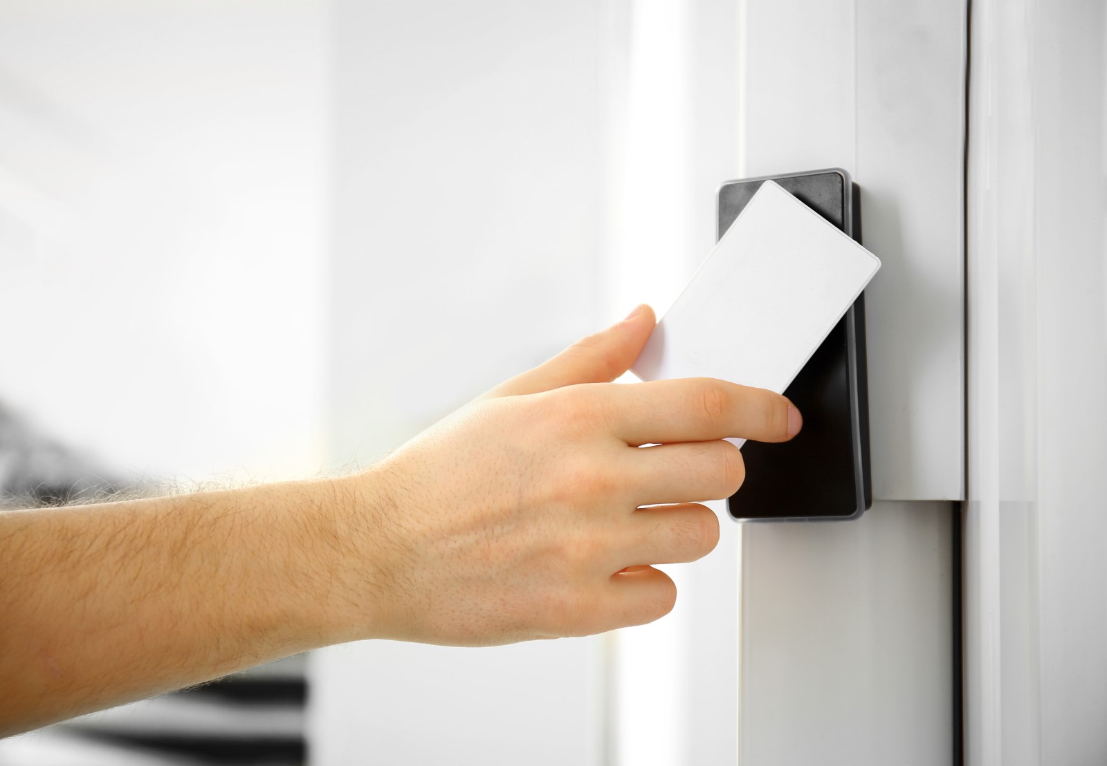 A man using a keycard access control system to gain entry into his office.