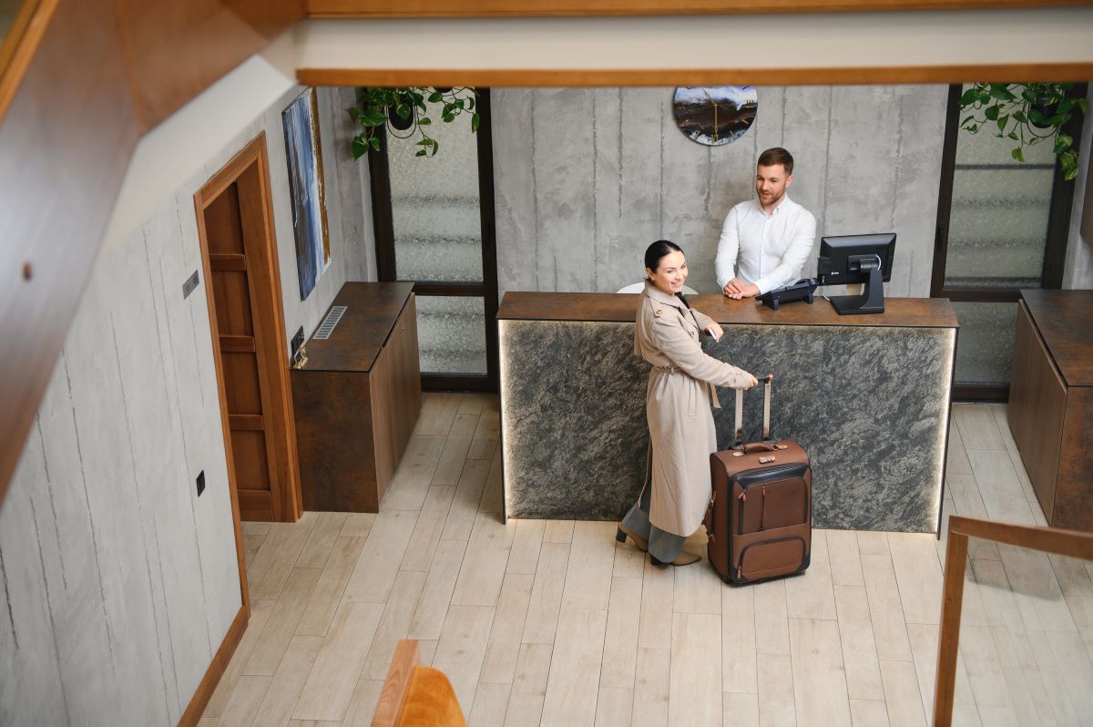 Overhead view of a guest checking in at the front desk of a boutique hotel.